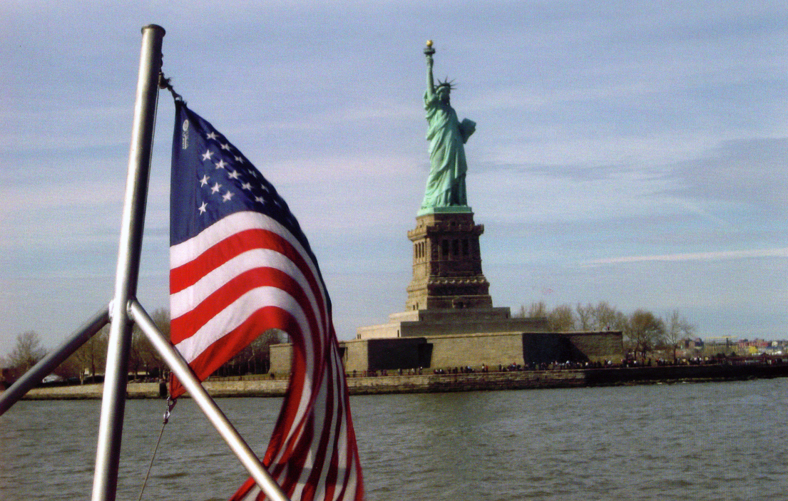 American flag in front of the Statue of Liberty